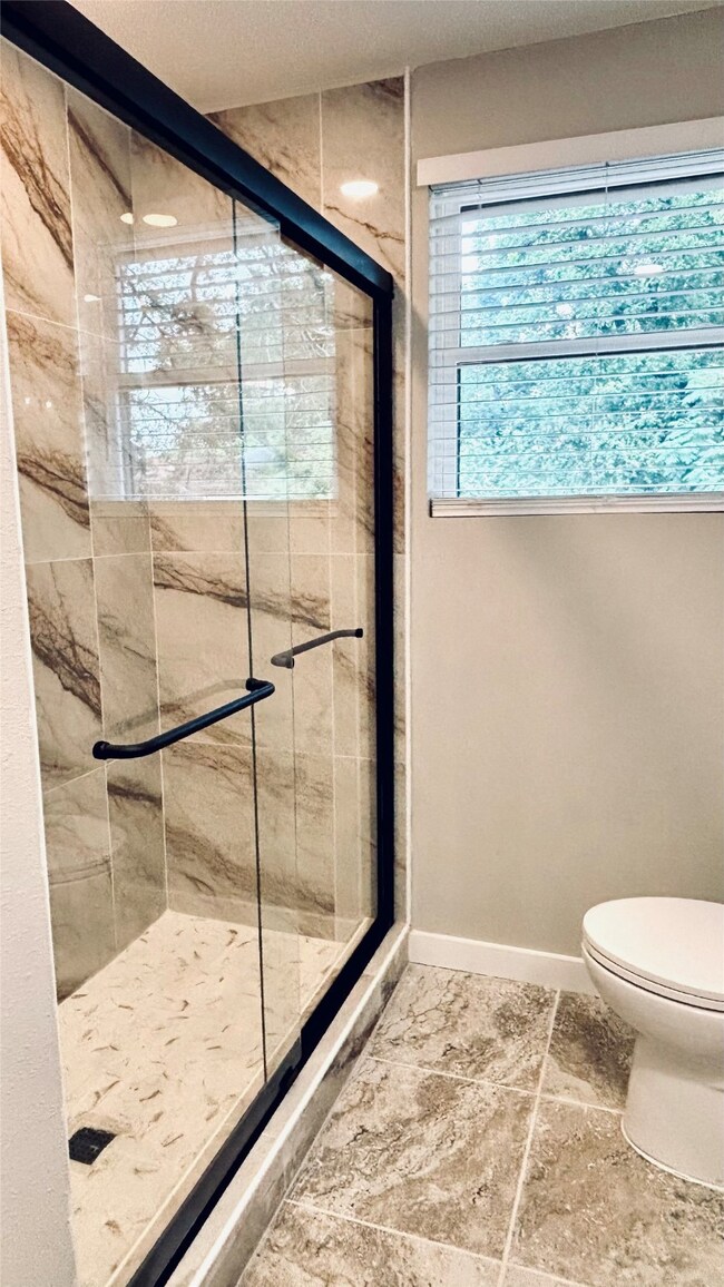 Full bath with a shower stall and toilet