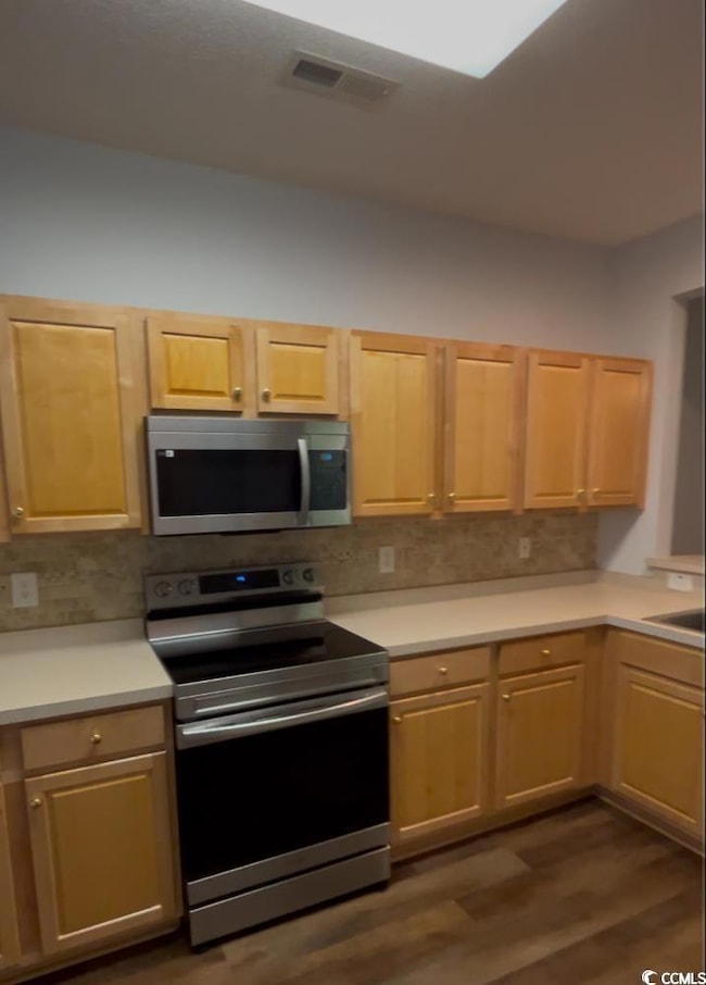 Kitchen with light countertops, appliances with st
