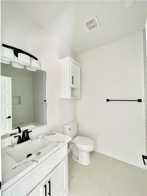 Bathroom featuring toilet, tile flooring, and oversized vanity