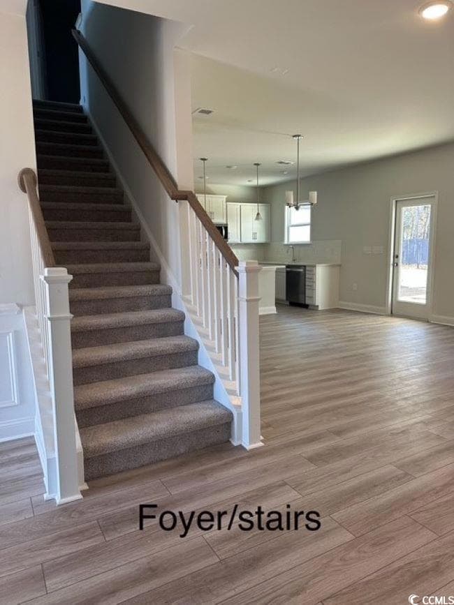 Staircase featuring plenty of natural light, sink,