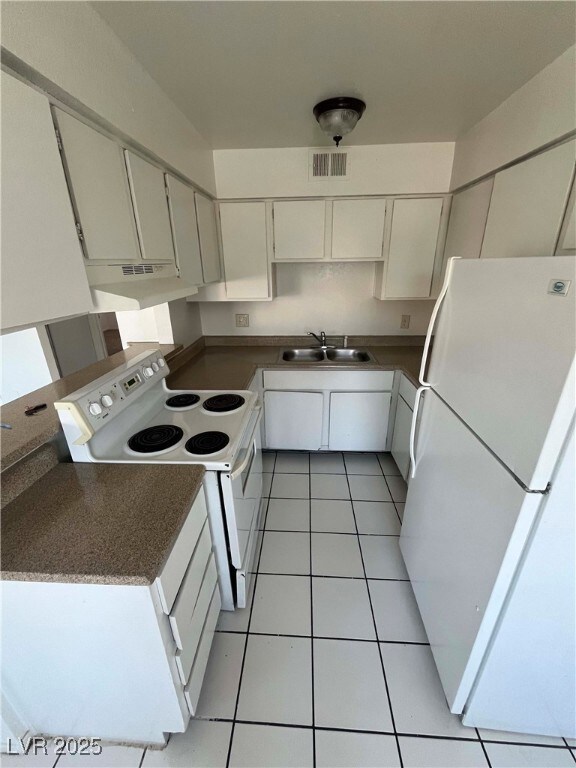 Kitchen featuring white appliances, a sink, under
