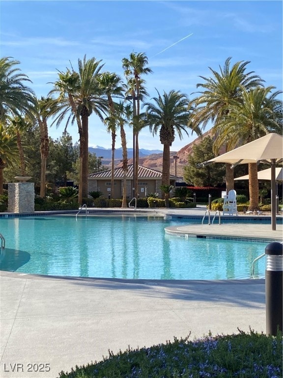 Community pool with a patio and a mountain view