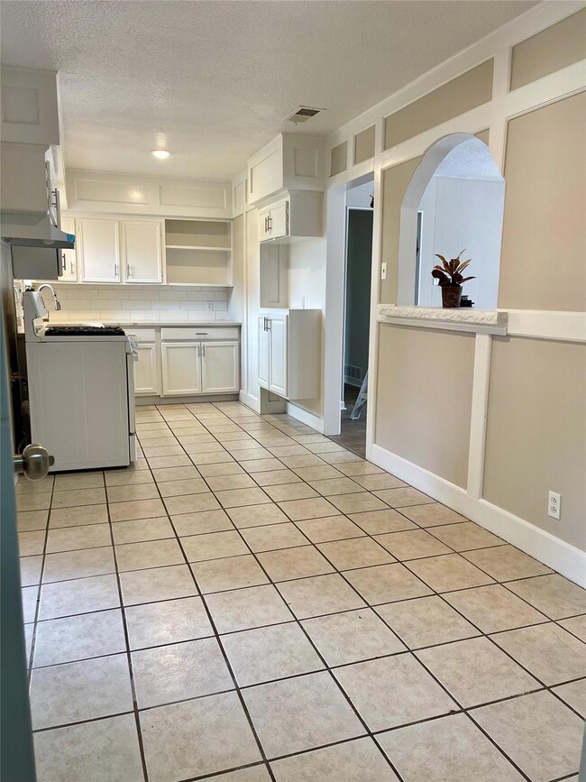Kitchen featuring white gas range, washer / dryer,