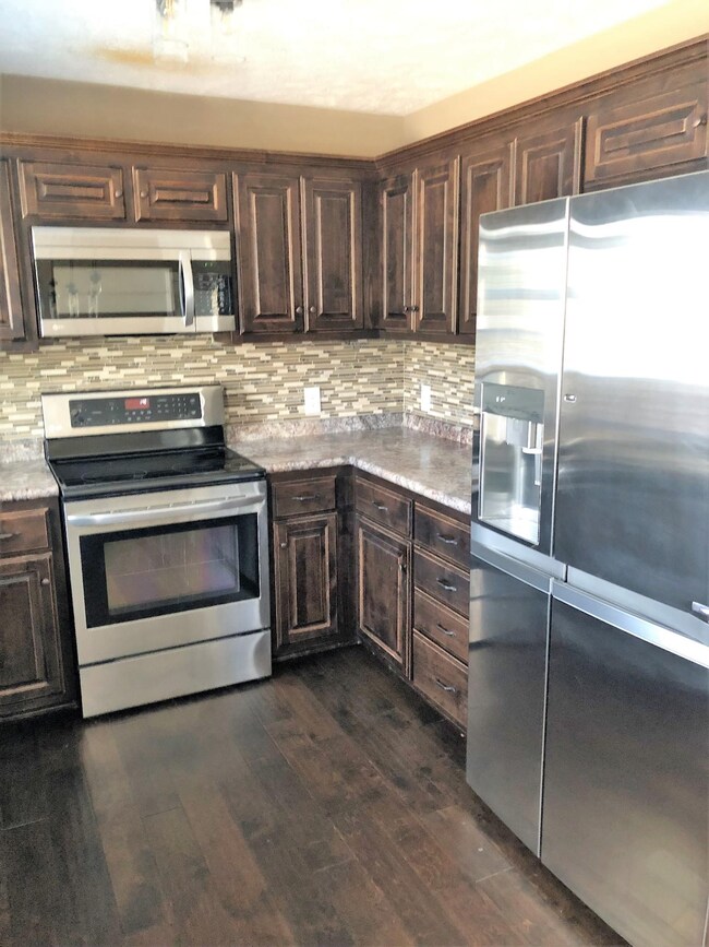 Stainless Steel appliances and tile backsplash around entire kitchen