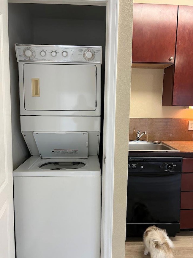 Washroom featuring stacked washing maching and dr