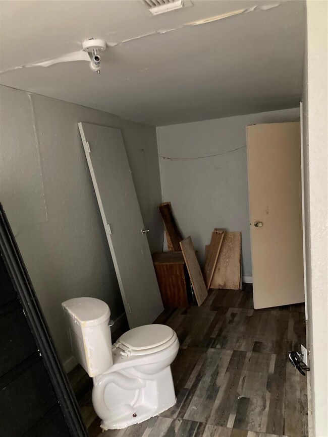 Bathroom with hardwood / wood-style floors and toi