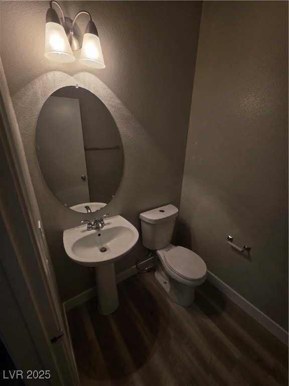 Half bathroom with dark wood-type flooring and a textured wall