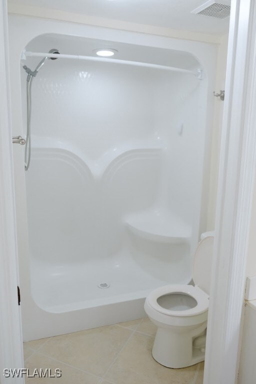 Bathroom with tile patterned flooring, a shower, a