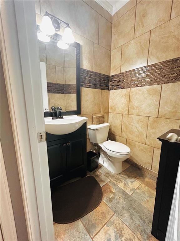 Half bath featuring vanity, stone tile floors, til