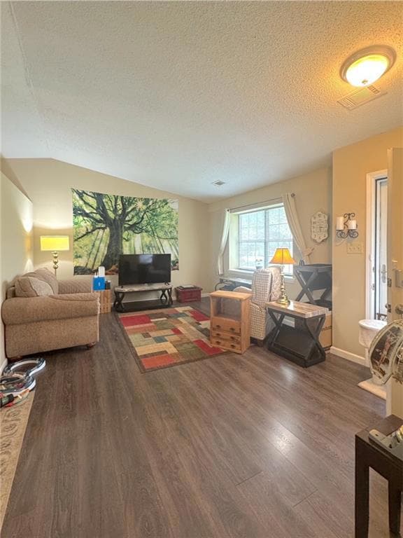 Living room featuring wood finished floors, a textured ceiling, and baseboards