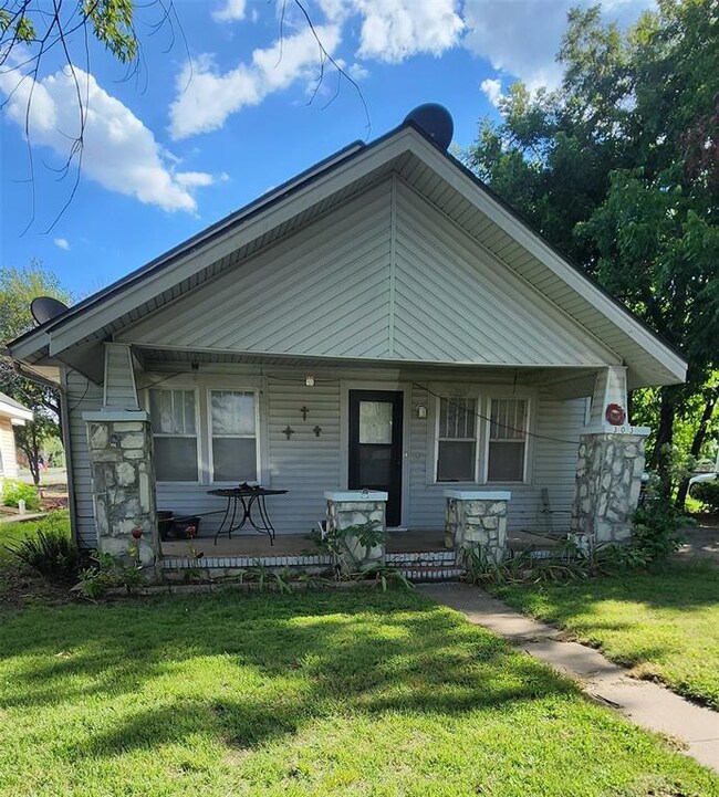 Bungalow with covered porch and a front lawn