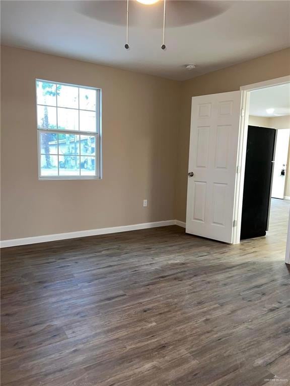 Empty room featuring dark wood-type flooring