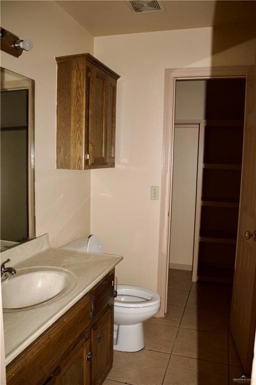 Bathroom featuring visible vents, toilet, tile patterned flooring, and vanity