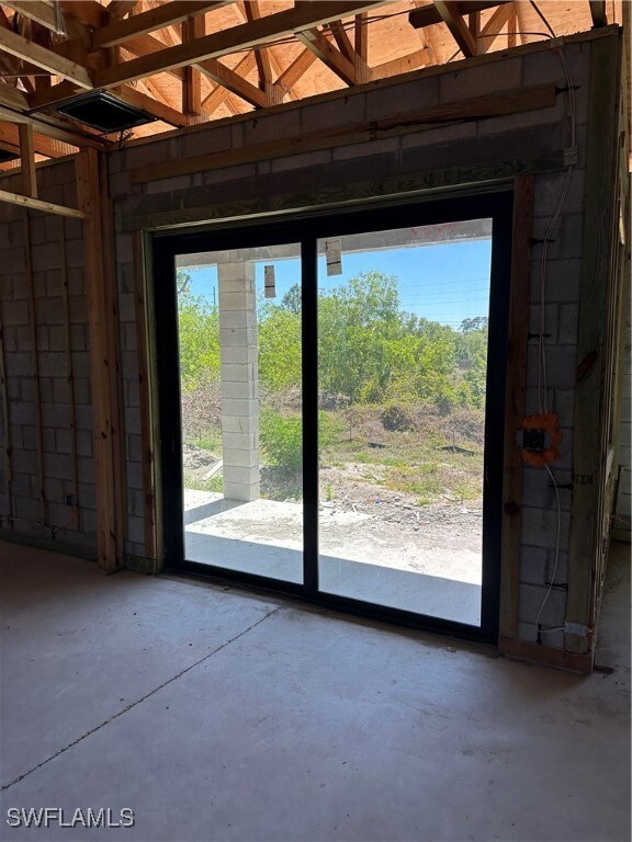 Entryway with unfinished concrete flooring and a h