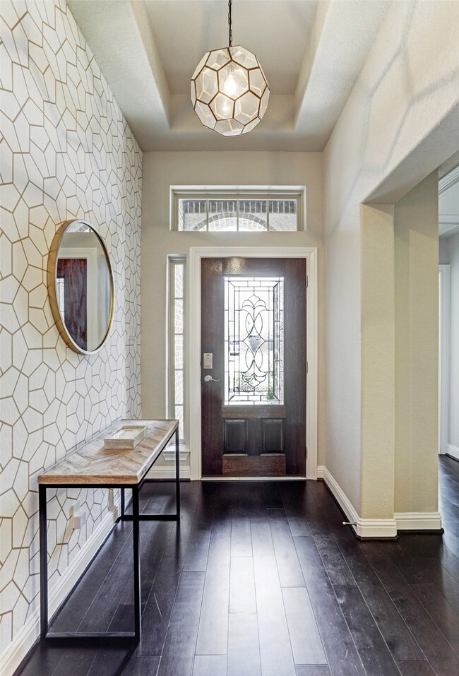 Spectacular entrance hall complete with modern wallpaper and light fixture sets the precedent for this amazing interior.