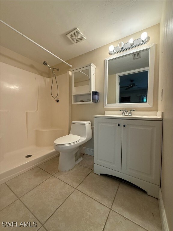 Full bath with tile patterned flooring, a shower, and vanity