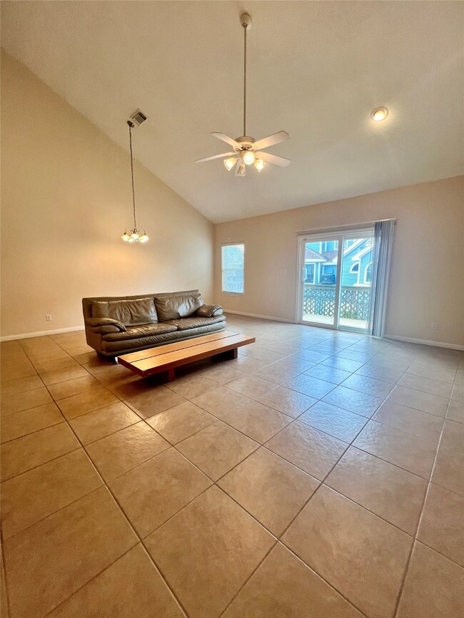 Spacious living room with high ceiling, tile floor
