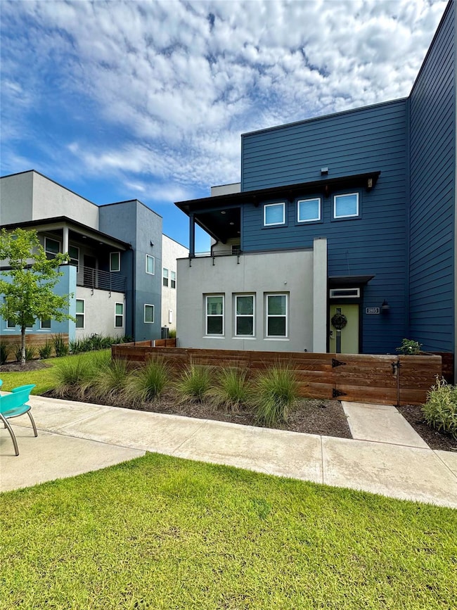 Back of property featuring a lawn and stucco sidi