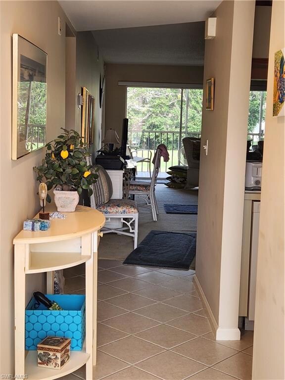Hall with tile patterned flooring and a healthy am