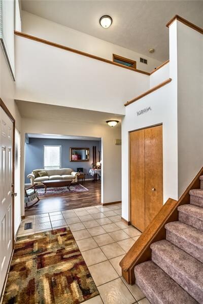 2 Story Entry has neutral wall and floor colors - ceramic tiled flooring throughout entry and partial bathroom.
