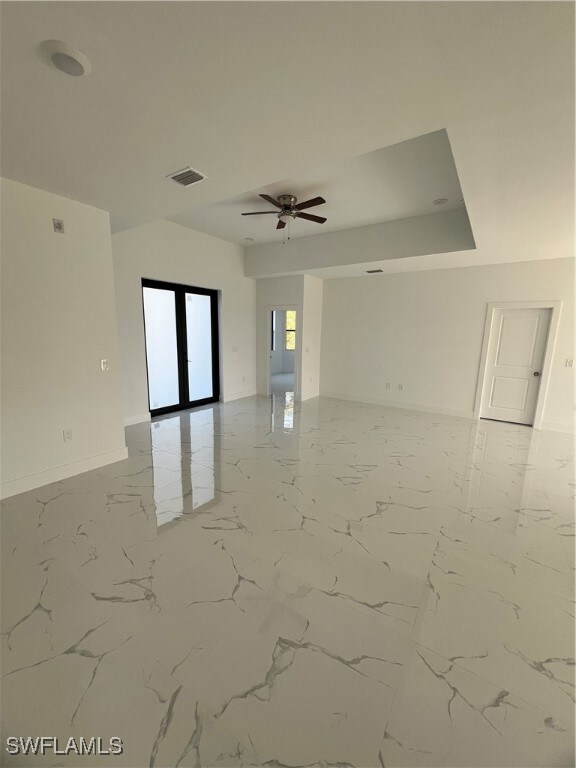Empty room with baseboards, visible vents, a ceili