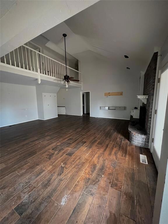 Unfurnished living room featuring high vaulted cei