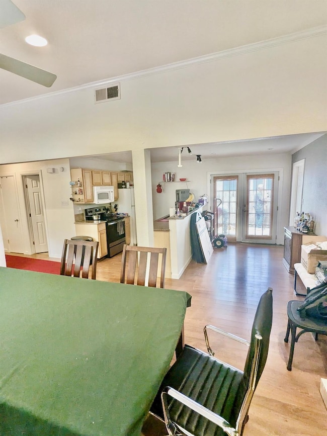 Dining room with ornamental molding, light wood-t