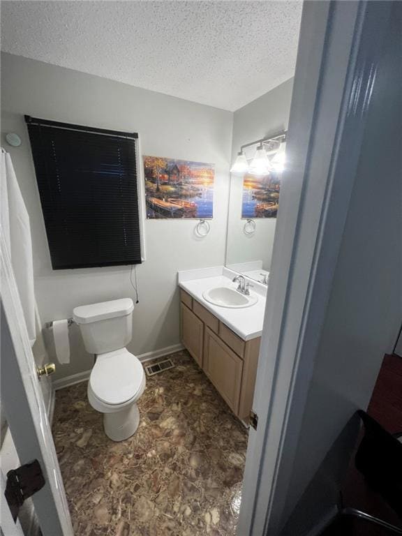 Bathroom with a textured ceiling, toilet, visible 