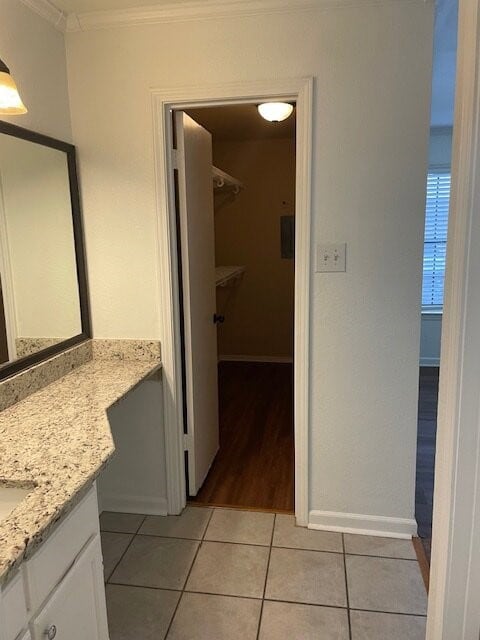 Bathroom featuring vanity, light tile patterned flooring, and ornamental molding