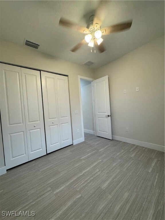 Unfurnished bedroom featuring a closet, baseboards
