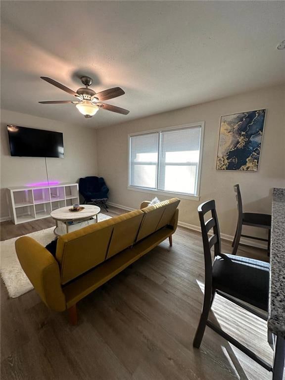 Living room with baseboards, a ceiling fan, and wo
