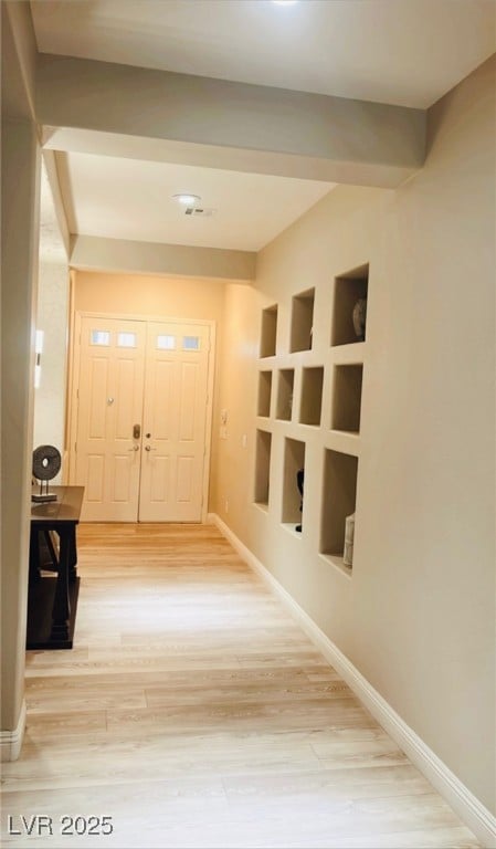 Hallway with light wood finished floors, baseboard
