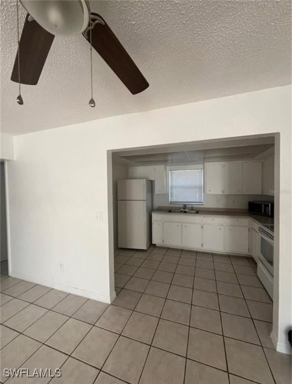 Kitchen featuring freestanding refrigerator, range