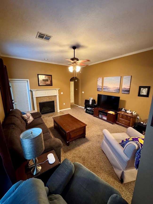 Living room featuring crown molding, ceiling fan, 