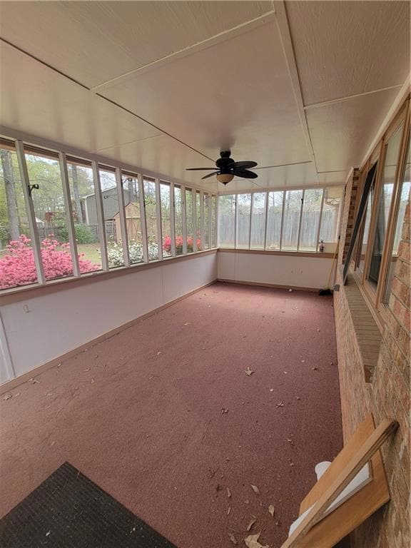 Unfurnished sunroom featuring ceiling fan