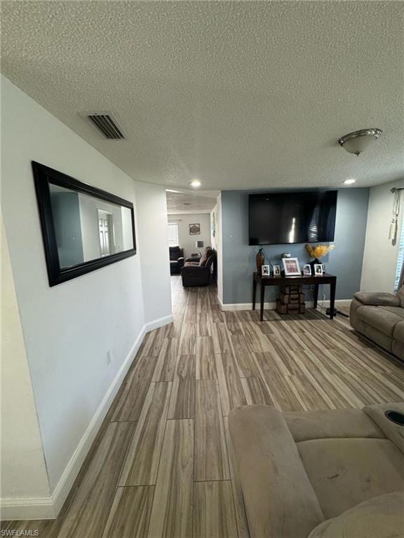 Living area featuring a textured ceiling, visible 
