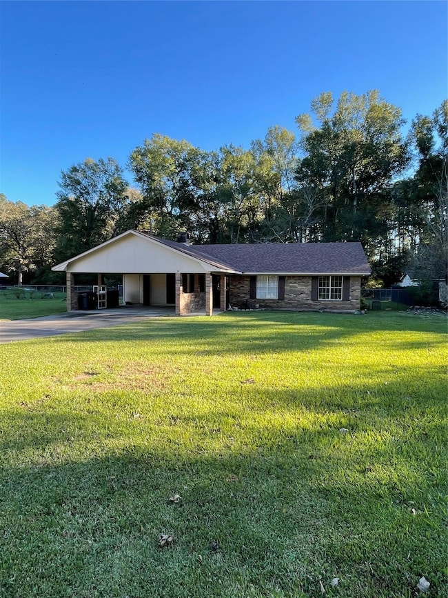 Ranch-style home with a front yard and a carport