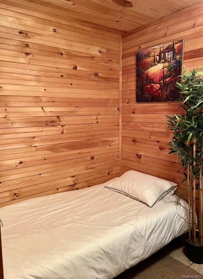 Bedroom with wood walls and wood ceiling