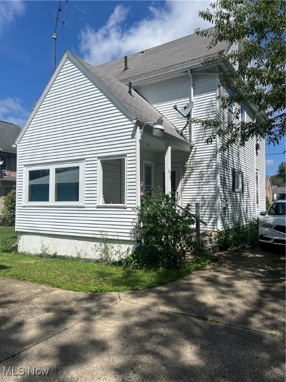 View of side of home featuring a shingled roof
