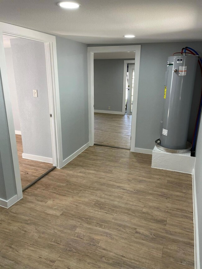 Corridor featuring electric water heater, a textur