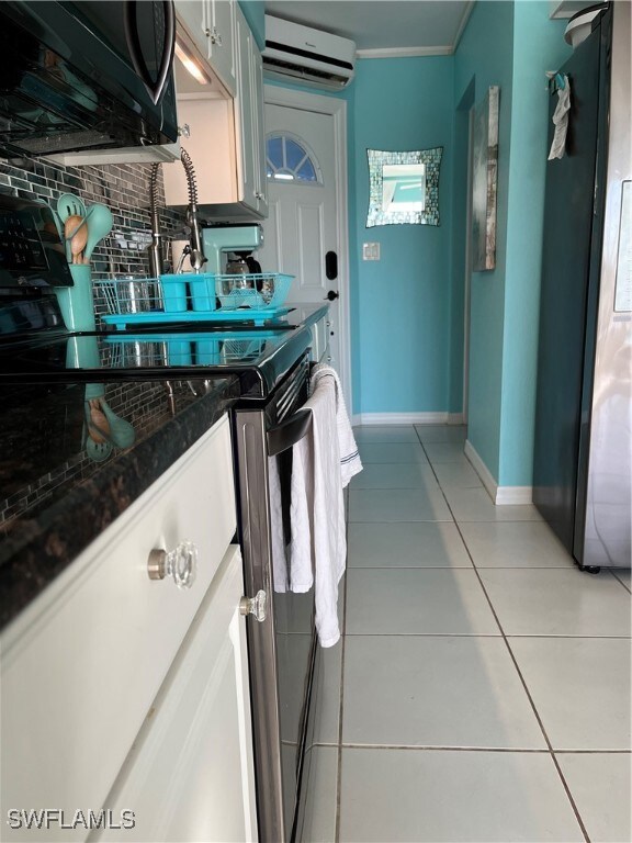 Kitchen with an AC split unit,  range, light tile