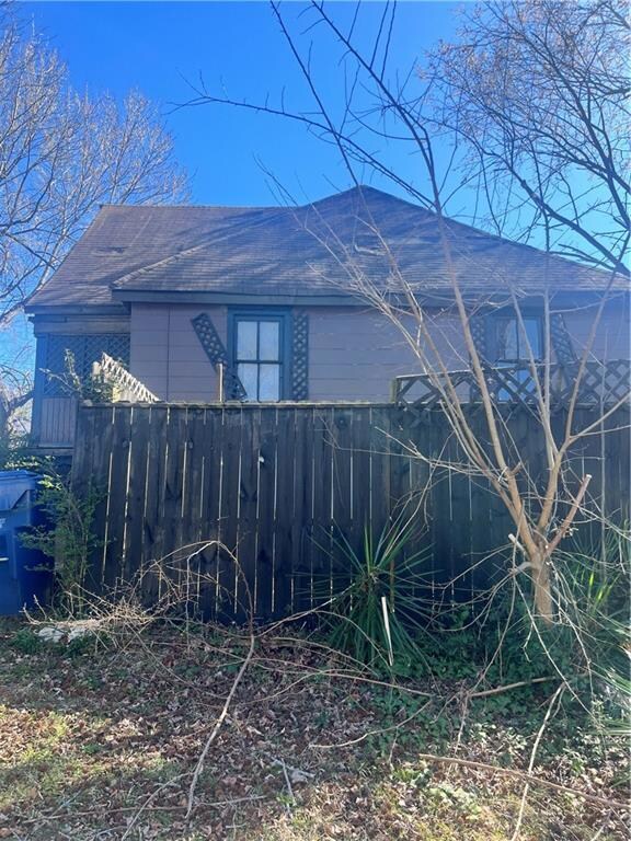 View of side of property with a shingled roof