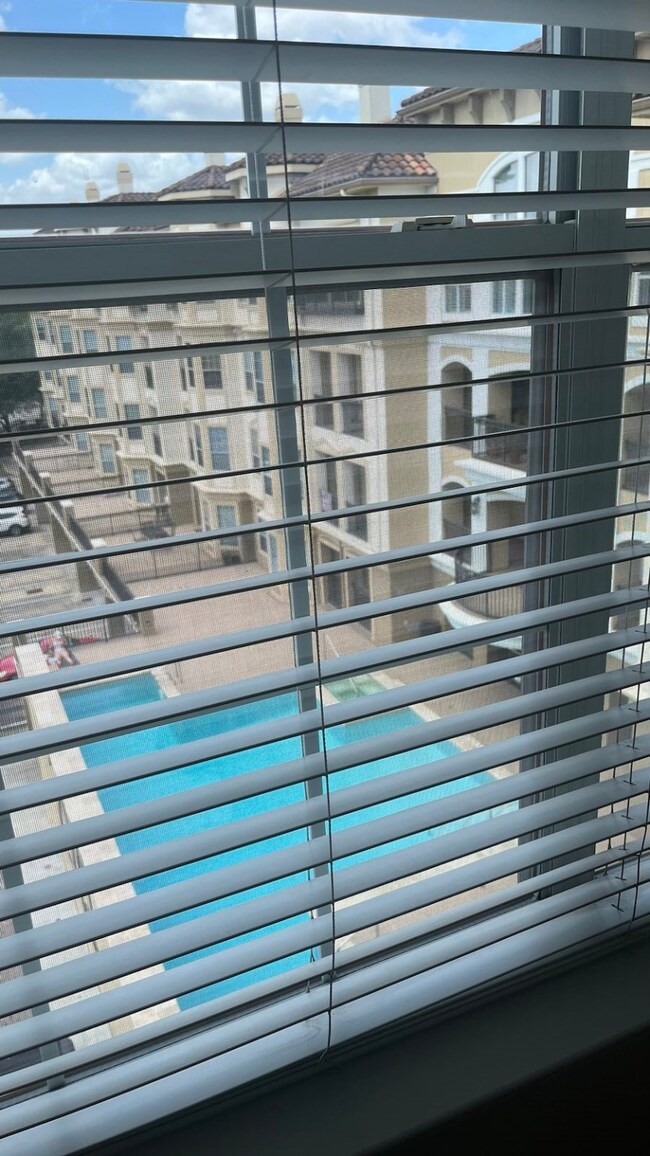 View of the pool through curtains of primary bedro