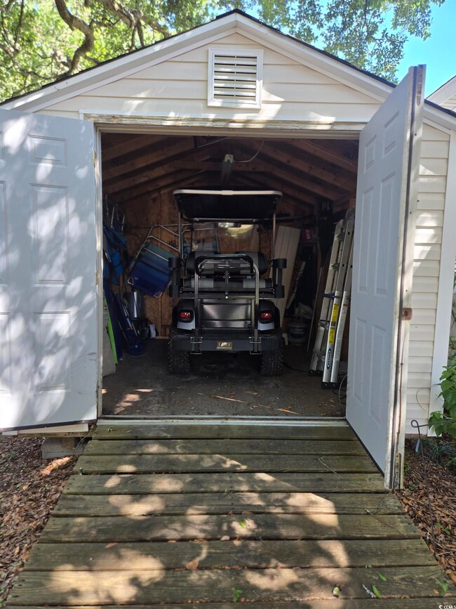 View of vehicle parking with a detached garage