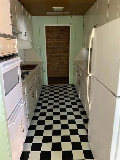 Kitchen featuring white appliances, tile patterne