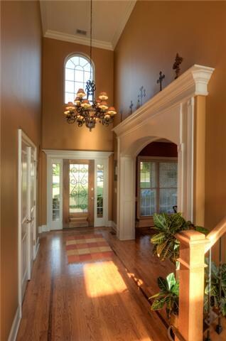 An inviting foyer with soaring celling, elaborate iron chandelier, arched doorways create a warm welcome for friends and family.