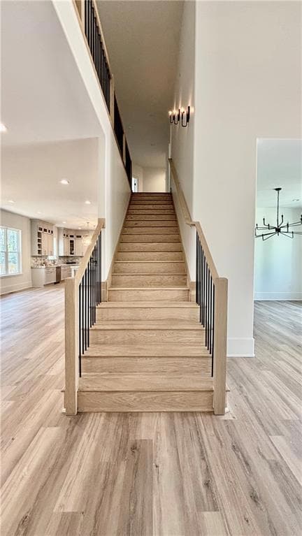 Stairs of the foyer featuring light hardwood / woo