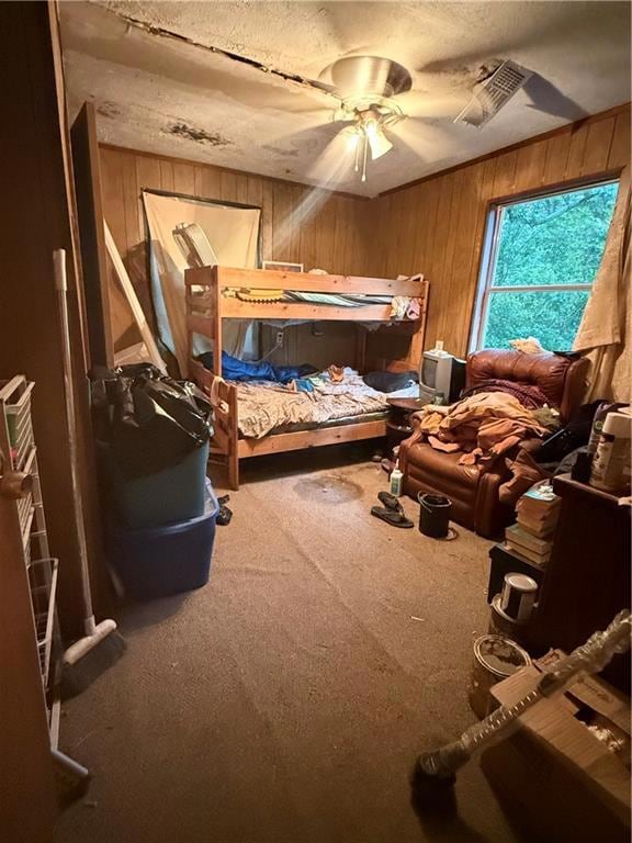 Carpeted bedroom featuring wood walls and a textur