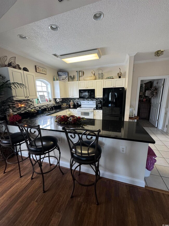 Kitchen with a kitchen bar, light wood-type floori