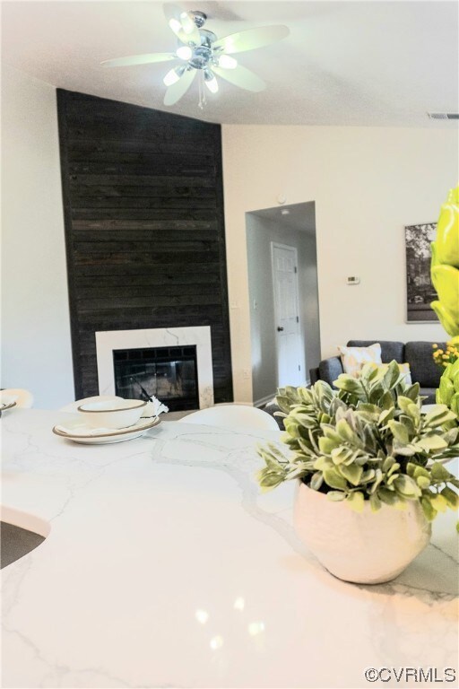 Living room featuring ceiling fan and a large fire